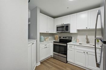A kitchen with white cabinets and stainless steel appliances